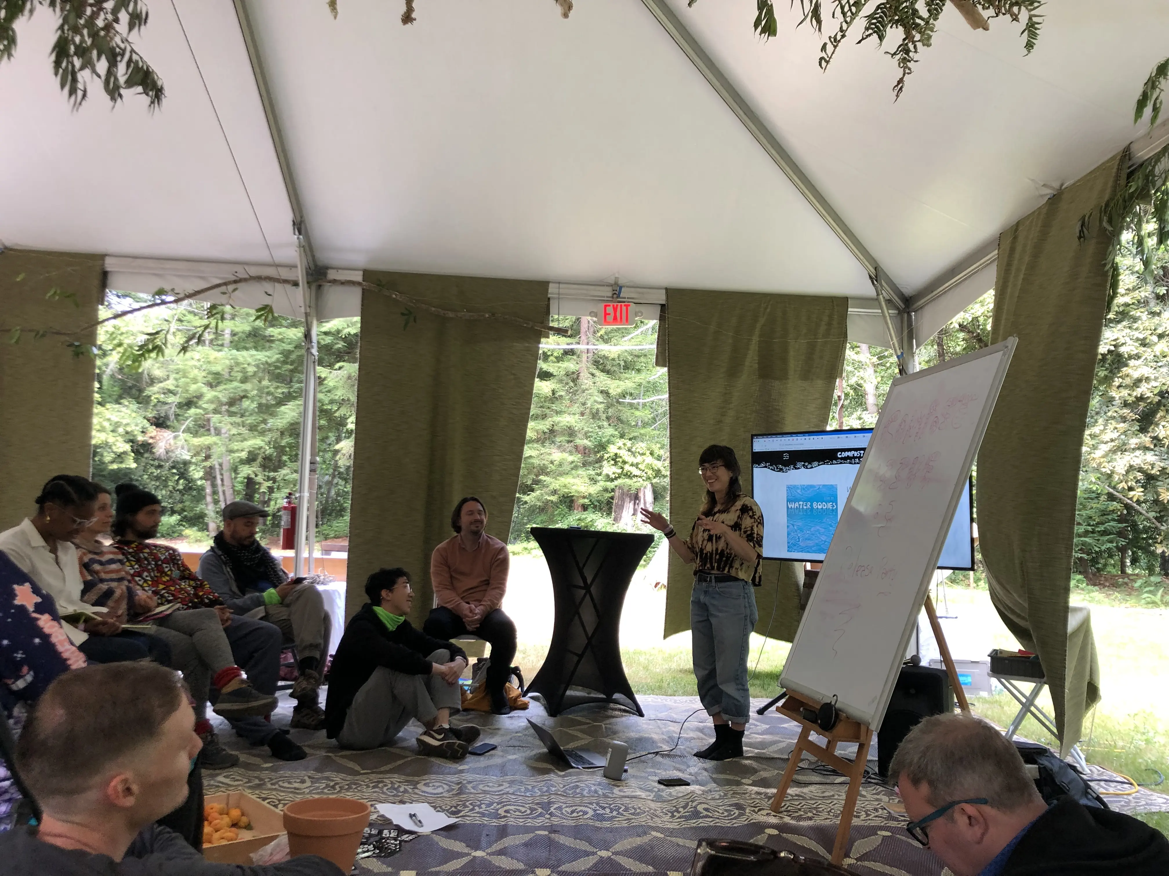 A group of people gathered under a tent for COMPOST Issue 3 release